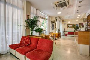 a living room with a red couch and a table at Hotel Tiziana in Rimini