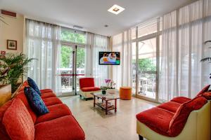 a living room with a red couch and a tv at Hotel Tiziana in Rimini