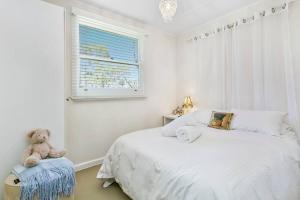 a teddy bear sitting on a chair in a bedroom at Lavender Cottage Leura in Leura