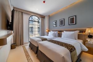 - 2 lits dans une chambre d'hôtel avec fenêtre dans l'établissement MONTANA @OCEANSIDE MANDALIKA, à Kuta Lombok