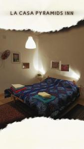 1 dormitorio con 1 cama con edredón azul en La Casa pyramids Inn en El Cairo
