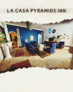 a living room with blue chairs and a fireplace at La Casa pyramids Inn in Cairo