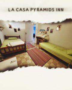 a room with two beds and a table in it at La Casa pyramids Inn in Cairo