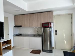 a kitchen with a refrigerator and a sink at Bright & Breezy 2 BR Unit with Balcony in Manila