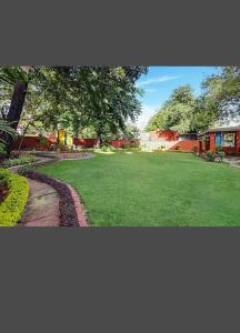 un patio verde con una pasarela y un edificio en YWCA International Guest House, en Nueva Delhi