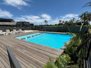 a swimming pool next to a wooden deck at 128 The Millennial in Durban