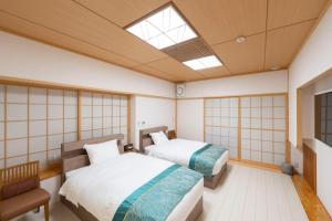 two beds in a room with a skylight at 舜山荘-元箱根 貸切別荘-最大人数9名 in Moto-hakone