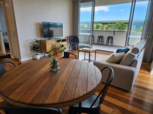 a living room with a wooden table and a couch at Spacious Modern Apartment in Prime Location in Wickham