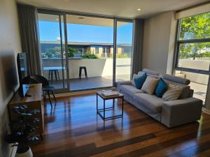 a living room with a couch and a table at Spacious Modern Apartment in Prime Location in Wickham