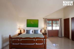 ein Schlafzimmer mit einem Bett mit zwei Lampen und einem Fenster in der Unterkunft StayVista at Mikkie House 3 Bedroom Villa in Aivarkhandpur