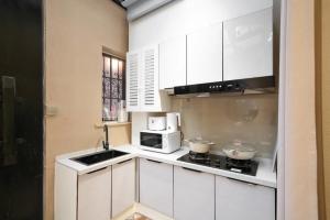 a kitchen with white cabinets and a microwave at Shanghai Hills & Serendipity Boutique in Shanghai