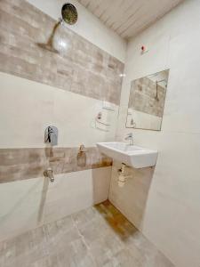 een badkamer met een wastafel en een spiegel bij Park View Residency in Bhuj