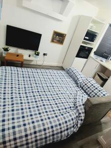 a bedroom with a bed and a flat screen tv at Femros Apartments, 15mins to city center. in Smethwick