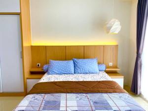 a bedroom with a bed with blue pillows at Apt Vasanta Innopark Studio S1oN with Pool in Jarakasta