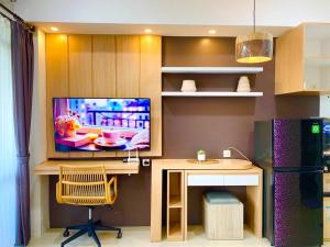 a kitchen with a desk and a tv on a wall at Apt Vasanta Innopark Studio S1oN with Pool in Jarakasta