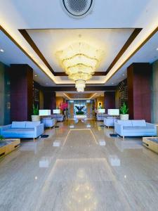 a lobby with couches and a chandelier in a building at Apt Vasanta Innopark Studio S1oN with Pool in Jarakasta