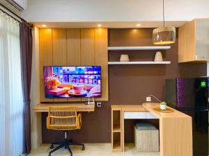 a living room with a tv on a wall with a desk at Apt Vasanta Innopark Studio S1oN with Pool in Jarakasta