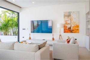 a living room with two white couches and a tv at Modern Villa Walking Distance to Fisherman Village KBR15 in Amphoe Koksamui