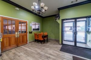 a dining room with green walls and a table and chairs at Holiday Terrace Motel in Houston