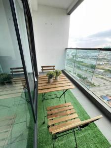 10 Pax-Cozy Family Suite Landmark 2 في كاجانغ: شرفة مع كرسيين خشبيين ونافذة