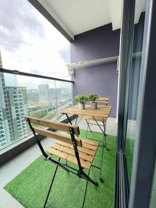 10 Pax-Cozy Family Suite Landmark 2 في كاجانغ: شرفة مع مقعد خشبي وطاولة على نافذة