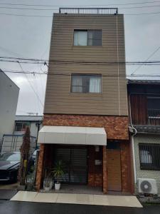 a tall brick building with a store front at Luck House Guest Huose in Osaka