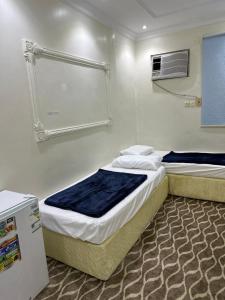 a bedroom with two beds and a window at فندق البديل in Al Madinah