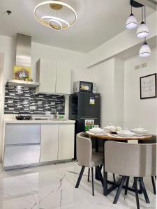 a kitchen with a table and chairs and a refrigerator at Azure Urban Resort - CITY VIEW 1BR - PS4, Billiards, Netflix, Karaoke in Manila