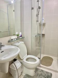 a bathroom with a toilet and a sink and a shower at Azure Urban Resort - CITY VIEW 1BR - PS4, Billiards, Netflix, Karaoke in Manila