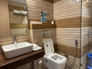La salle de bains est pourvue d'un lavabo et de toilettes. dans l'établissement Hotel River Retreat, à Kangra