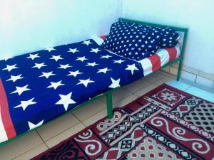 a bed with an american flag blanket on it at Kos Omah Yanto 19 in Jakarta