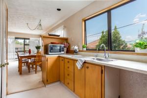 uma cozinha com um lavatório e uma grande janela em Prime Location! 4BR Sunny Character Home near CBD Auckland em Auckland