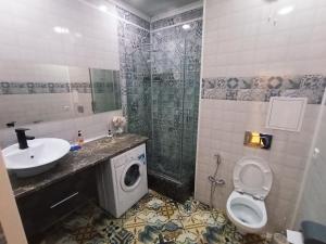 uma casa de banho com um lavatório, um WC e um chuveiro em Светлая квартира в сердце города em Almaty