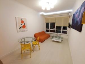 uma sala de estar com uma mesa e cadeiras e um sofá em Светлая квартира в сердце города em Almaty