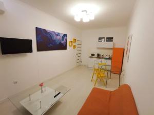 uma sala de estar com um sofá laranja e uma mesa em Светлая квартира в сердце города em Almaty