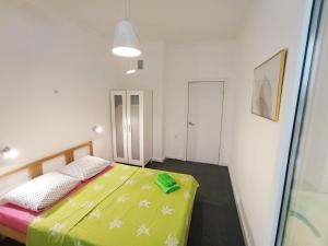 um quarto com uma cama com um edredão verde em Светлая квартира в сердце города em Almaty