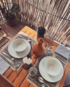 a wooden table with plates and utensils on it at Kazacérola in Fort-de-France