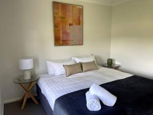 a bedroom with a bed with two pillows on it at Stylish Open Plan Retreat in Wagga Wagga