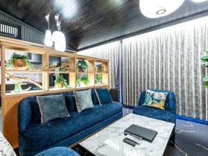 Tabist kiki HOTEL KYOTO Sanjo Takakura في كيوتو: غرفة معيشة مع أريكة زرقاء وطاولة