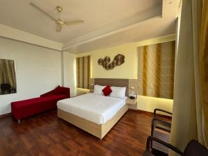 a bedroom with a bed and a red couch at Hotel River Retreat in Kangra