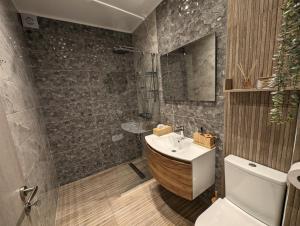 a bathroom with a wooden tub and a sink at Modern mint sunny house near the airport in Spáta