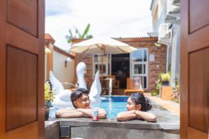 two girls laying in a swimming pool at Alam Canggu Kuta by ABM in Canggu