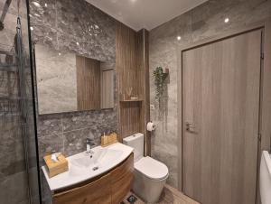 uma casa de banho com um lavatório e um WC em Modern mint sunny house near the airport em Spata