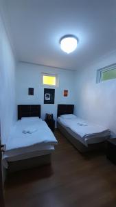 Pokój z 2 łóżkami i lampką na ścianie w obiekcie Noa Hostel and Guest House w mieście Nachiczewan