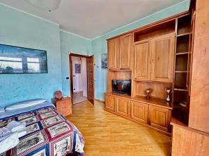 1 dormitorio con 1 cama y armarios de madera en Finestra sulle Alpi e Golf, en Fiano