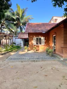 a house with a palm tree in front of it at Cabana Capybara in Mirissa +10 photos