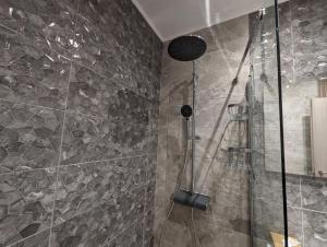 La salle de bains est pourvue d'une douche avec une porte en verre. dans l'établissement Modern mint sunny house near the airport, à Spáta