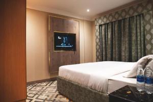 ein Hotelzimmer mit einem Bett und einem TV in der Unterkunft Terrace Furnished Apartments- Fintas1 in Kuwait