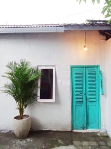 una porta verde e una pianta di fronte a una casa di Local House Grenceng 2 a Denpasar