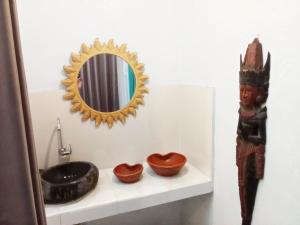 登巴薩的住宿－Local House Grenceng 2，浴室设有水槽和架子上的镜子